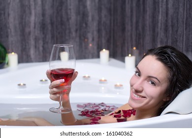 Beautiful Woman In Bath With Rose Petals Drinking Wine