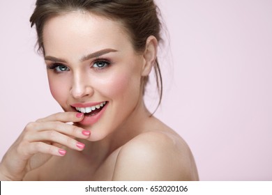Beautiful Woman With Beauty Face Makeup. Portrait Of Attractive Female Touching Smooth Facial Skin With Hand. Closeup Sexy Girl Model With Fresh Natural Makeup And Glamour Hairstyle. High Resolution