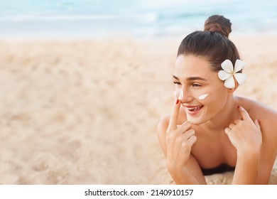 Beautiful Woman In Bikini Apply Sun Cream On Face. Woman With Suntan Lotion On Beach. Skin Care. Sun Protection. 