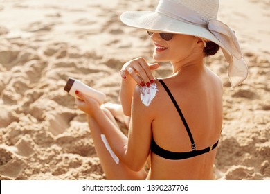 Beautiful Woman in Bikini Applying Sun Cream on Tanned Shoulder. Sun Protection. Skin and Body Care. Girl Using Sunscreen to Skin. Portrait Of Female Holding Suntan Lotion and Moisturizing Sunblock.