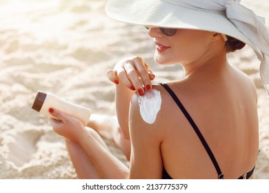 Beautiful Woman in Bikini Applying Sun Cream on Tanned  Shoulder. Sun Protection. Skin and Body Care. 