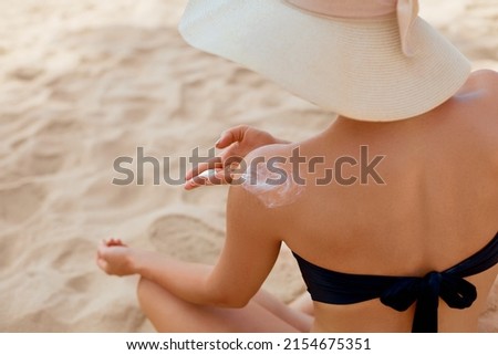 Beautiful Woman in Bikini Applying Sun Cream on Tanned Shoulder. Sun Protection. Skin and Body Care. Girl Using Sunscreen to Skin. Suntan Lotion and Moisturizing Sunblock