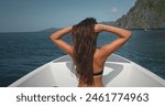 Beautiful woman in bikini on speed boat enjoy wild nature sea rock landscape. Long hair brunette girl relax, travel, tourism, holiday. Philippines, El Nido Islands, Boat tour. Back view, slow motion