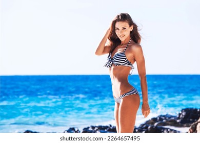 Beautiful woman in bikini. Young and sporty girl posing on a beach at summer. - Shutterstock ID 2264657495