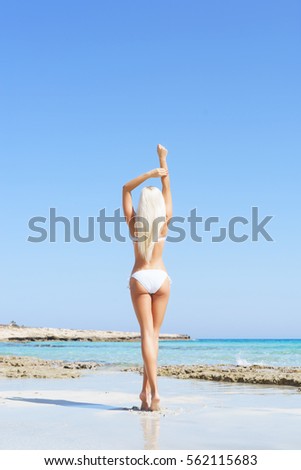 Beautiful woman in bikini. Young and sporty girl posing on a beach at summer.