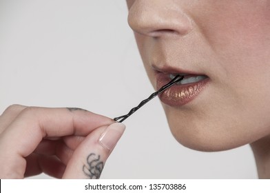 Beautiful Woman Biting A Bobby Pin Before Putting It Into Her Hair