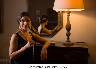 Beautiful Woman In Black Beaded 1920s Flapper Dress Looking Into Her Antique Mirror