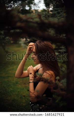 Similar – beautiful young woman siiting outdoors in forest, dreaming with closed eyes in serene pose