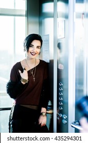 Beautiful Woman With Black Hair And Dark Lipstick Standing In The Elevator And Waits For The Floor