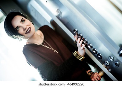 Beautiful Woman With Black Hair And Dark Lipstick Standing In The Elevator And Waits For The Floor Pressing A Button