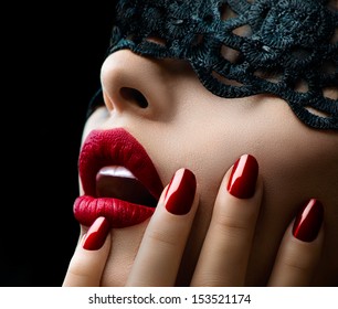 Beautiful Woman With Black Lace Mask Over Her Eyes. Red Sexy Lips And Nails Closeup. Open Mouth. Manicure And Makeup. Make Up Concept. Passion