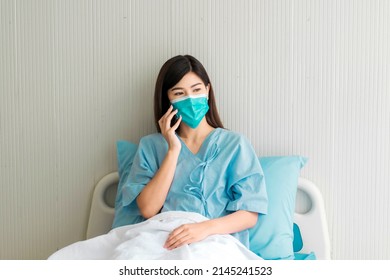 Beautiful Woman With Black Long Hair In Patient Gowns At A Hospital Bed Talking On The Phone. Selective Focus.