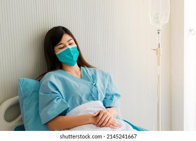 Beautiful Woman With Black Long Hair In Patient Gowns At A Hospital Bed Sleeping. Selective Focus.