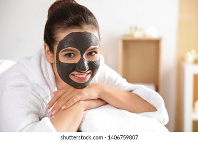 Beautiful Woman With Black Mask On Face Relaxing In Spa Salon. Space For Text