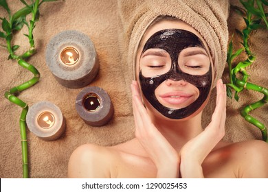 Beautiful Woman With Black Purifying Black Mask On Her Face. Beauty Model Girl With Black Facial Peel-off Mask Lying In Spa Salon. Skin Care, Acne Treatment, Cleansing   Skin. Peel Of Charcoal Mask