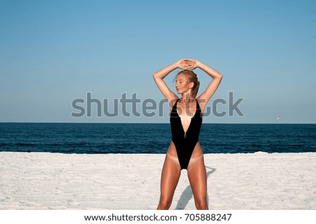 Beautiful woman in black swimsuit on the beach. Summer concept