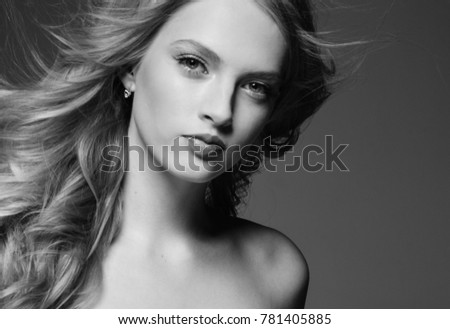 Beautiful woman with blonde long hair over gray background black and white