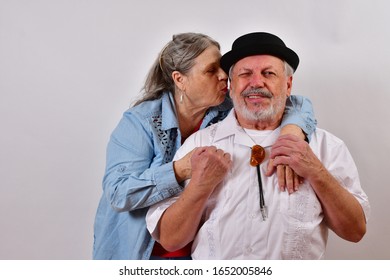 Beautiful Woman Blows Into The Old Man's Ear
Mature Couple Holding Hands And Facing The Camera