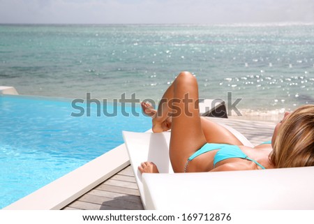 Beautiful woman in blue bikini taking the sun