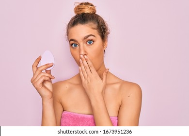 Beautiful Woman With Blue Eyes Wearing Towel Shower After Bath Holding Makeup Sponge Cover Mouth With Hand Shocked With Shame For Mistake, Expression Of Fear, Scared In Silence, Secret Concept