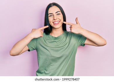 Beautiful woman with blue eyes wearing casual t shirt smiling cheerful showing and pointing with fingers teeth and mouth. dental health concept.  - Powered by Shutterstock