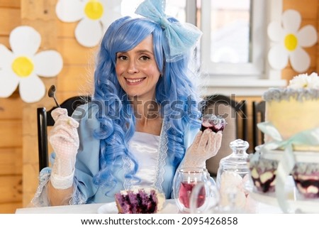 Beautiful woman with blue wig in a dress in the house.