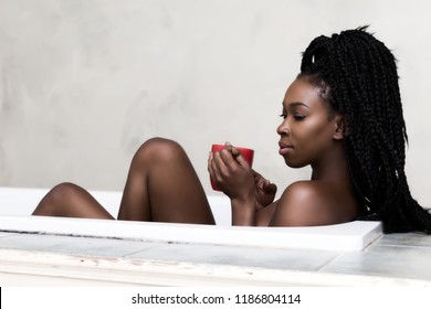 Beautiful woman with braided hair dreaming in bath tub