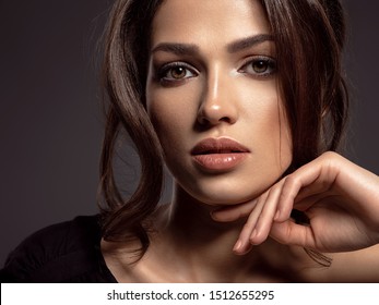 Beautiful woman with brown hair. Attractive model with brown eyes. Fashion model with a smokey makeup. Closeup portrait of a pretty woman looks at camera. Sexy woman.