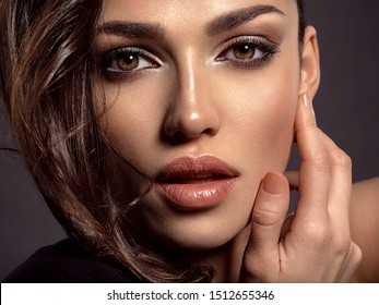 Beautiful woman with brown hair. Attractive model with brown eyes. Fashion model with a smokey makeup. Closeup portrait of a pretty woman looks at camera. Sexy woman.