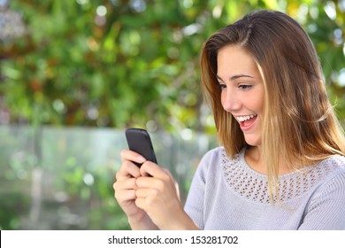 Beautiful Woman Browsing Internet Happy In Her Smart Phone With A Green Background               