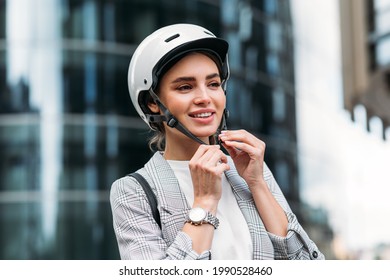 Beautiful Woman In Businesswear Putting Cycling Helmet On A City Street Before A Ride