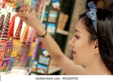 Beautiful woman buying souvenirs in gift shop