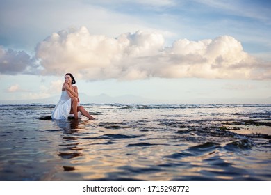 Schöne Frau am Meer bei Sonnenuntergang
