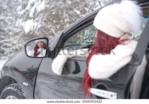 beautiful woman in\
the car looking in the car mirror winter,  \
travel road woman\
driving, \
Christmas car ride.\
