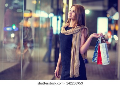 Beautiful woman carrying many shopping bags on a city street