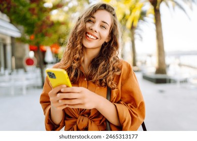 Beautiful woman in casual clothes standing on the street and text messaging. Lifestyle, travel, tourism, technology, blogging, communication concept