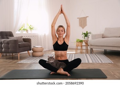 Beautiful Woman With Cat Practicing Yoga At Home