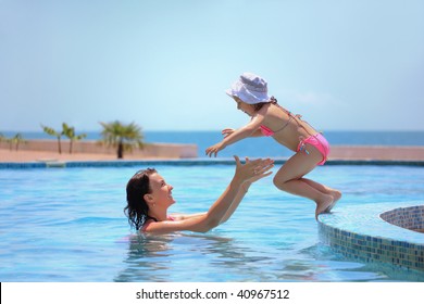 Beautiful Woman Catches Little Girl Jumping In Pool Against Sea