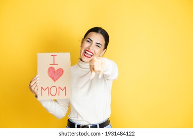 Beautiful Woman Celebrating Mothers Day Holding Poster Love Mom Message Laughing At You, Pointing Finger To The Camera With Hand Over Body, Shame Expression