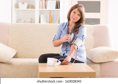 Beautiful Woman Checking Her Blood Pressure At Home