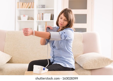 Beautiful Woman Checking Her Blood Pressure At Home