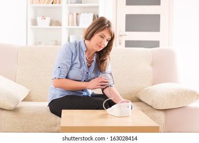 Beautiful Woman Checking Her Blood Pressure At Home