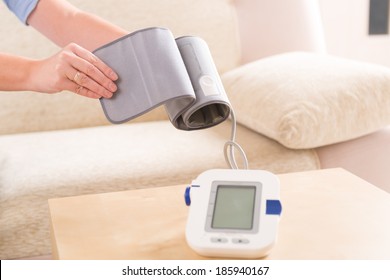 Beautiful Woman Checking Her Blood Pressure At Home And Presenting Pressure Monitor Cuff