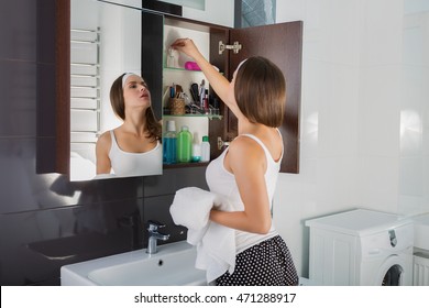 Beautiful woman choosing beauty products in her bathroom in the morning - Powered by Shutterstock