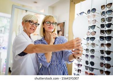 Beautiful Woman Choosing A Glasses In Optician Store.