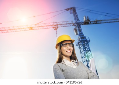 Beautiful Woman Civil Engineer Smiling With Confidence In Front Of A Crane In A Sunset Flare Background