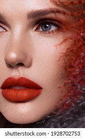 Beautiful woman with classic holiday make-up, red lips, curls in a multi-colored llama coat. Beauty face. Photo taken in studio