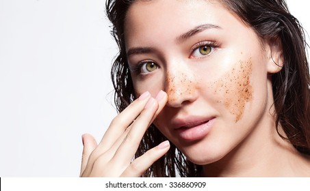 Beautiful woman cleans the skin scrub on a white background isolated