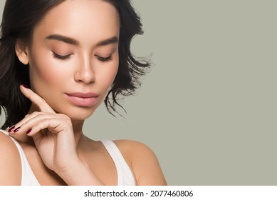 Beautiful Woman Close Up Face Asian Girl With Clean Fresh Healthy Skin. Color Background. Green