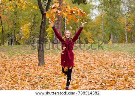 Beautiful woman in a coat park autumn leaves fly nature background
